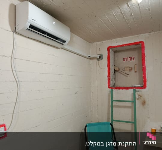 מזגן מותקן על קיר בחדר עם סולם וכיור